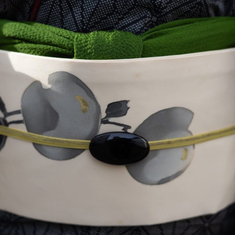 Moderne Version des Obidome Gefalteter Obi mit grauen Blumenmotiven und grünem Stoff.