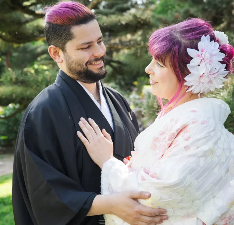 Kimono Fotoshooting Ein Paar in traditioneller japanischer Kleidung steht lächelnd in einem Garten.